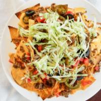 Super Nacho Supreme · Your choice of seasoned chicken or savory beef on top of house-made fried tortilla chips pil...