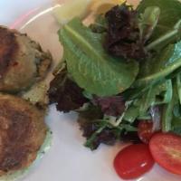 Crab Cakes · Two crab cakes pan-roasted & served with cilantro & jalapeno remoulade & crisp green salad.