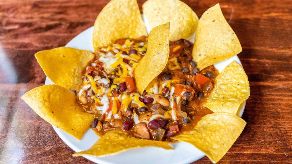 Chili · Steak, chicken andouille sausage with a blend of beans topped with cheese and served with nacho chips.