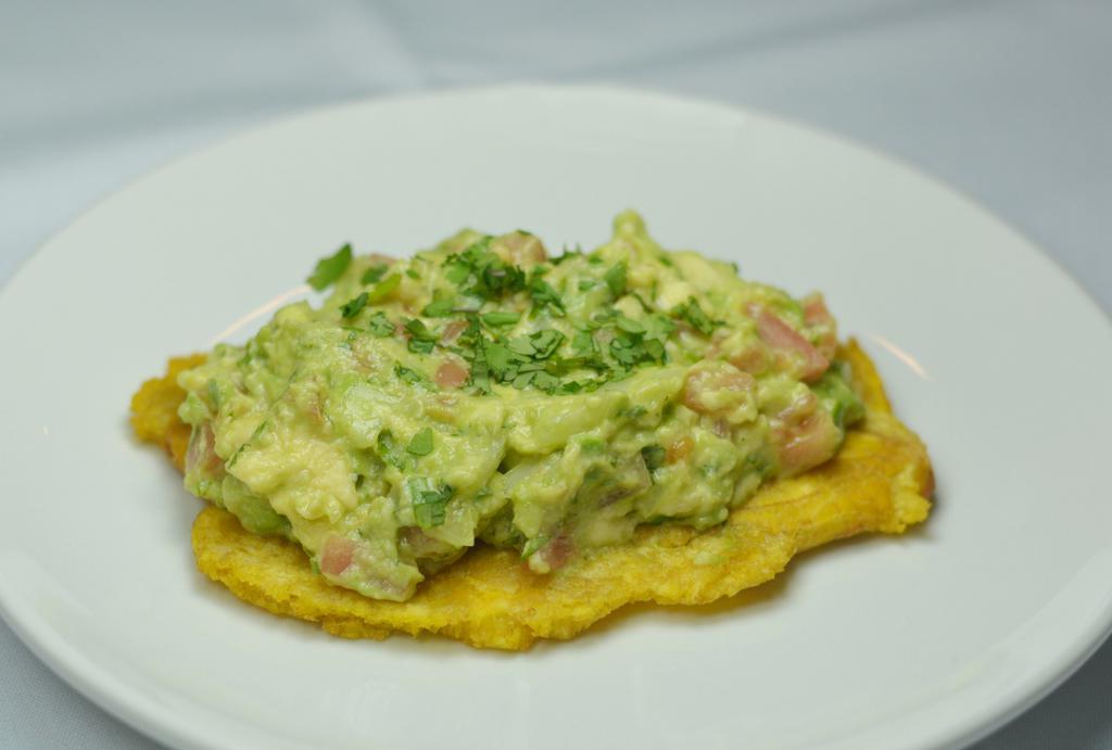 Toston Con Aguacate · Fried green plantain topped with choice of shredded chicken, shredded beef, or guacamole.