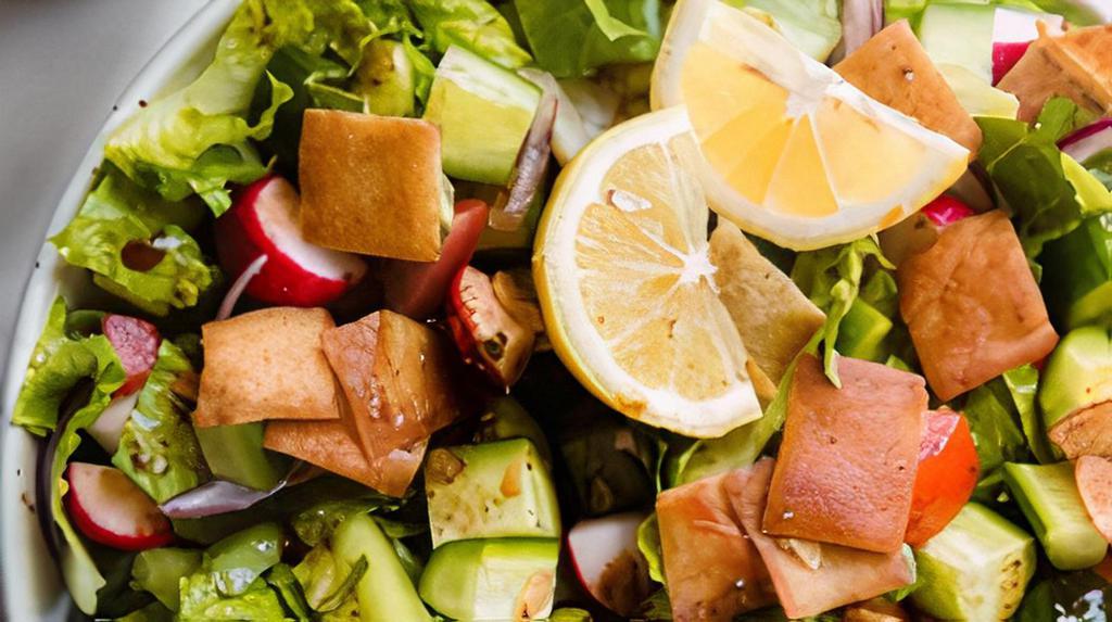 Fattoush Salad · Lettuce, tomatoes, cucumbers, bell pepper, onions, radish, parsley, oil, lemon juice, apple cider, greens, pomegranate molasses, and pita chips.