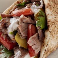 Beef And Lamb Shawarma Wrap · Onions, parsley, tomatoes, tahini sauce, and pickles. Thinly sliced roasted meat.
