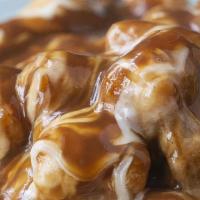 Poutine Tater Tots · Tater tots lightly salted, fried golden brown and topped with gravy & cheese!