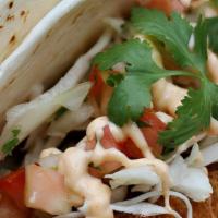 Crispy Fish Soft Tacos · 2 Soft tacos filled with Crispy Fish, slaw, & Yum Yum sauce on a soft sandwich roll with a s...