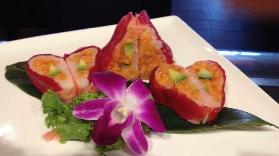 Salmon Hana · Sliced salmon wrapped around spicy crabmeat and mixed greens with spicy sauce.