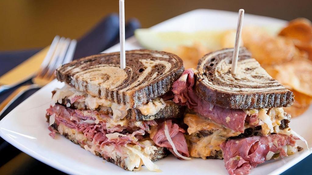Triple Decker Corned Beef Reuben · Corned beef pile high on three layers, sauerkraut, melted Swiss, and homemade Russian dressing on grilled marble rye