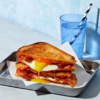 Bacon Breakfast Grilled Cheese · Melted cheddar, crispy bacon, fried egg, and tomato between two slices of buttery grilled br...