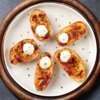 Spud Skins · Baked potato skins filled with cheddar cheese, bacon, scallions, and topped with sour cream.