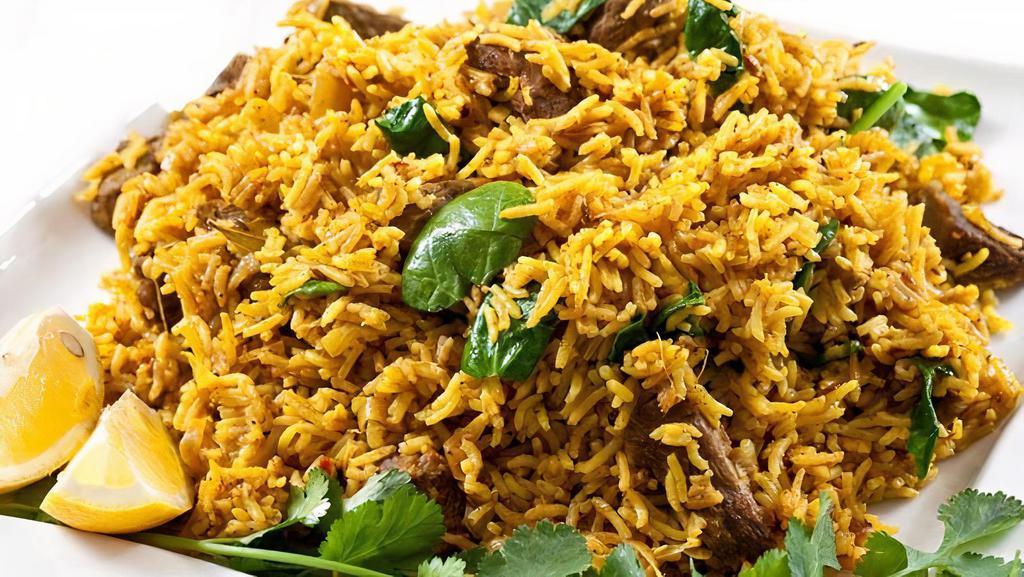 Goat Biryani · Our popular biryani is made authentically with fresh goat and fried onions cooked with our long grain basmati rice and our in-house biryani masala. Final garnishing includes white onions, cilantro, jalapeño, and lemon.