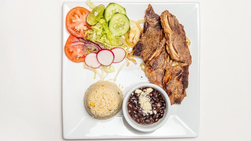 Costillas De Res Asadas · Grill beef ribs. Served with rice, salad, black beans and tortillas.