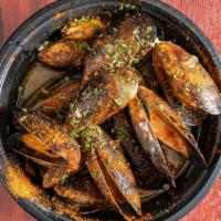 Mussels  · Black shell mussels in a white wine sauce, topped with seafood seasoning & drizzled with gar...
