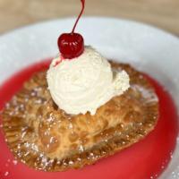 Pineapple Upside Down Empanada · Cinnamon and ginger pineapple empanada served with cherry syrup, caramel sauce, Chantilly cr...