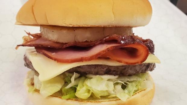 Pastrami Burger · 1/4 lb patty topped with grilled pastrami and swiss cheese on a seeded bun dressed with mayo, lettuce, tomato, onion, and pickle