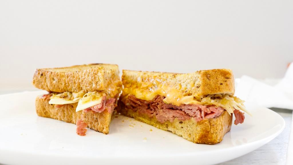 Reuben Sandwich · Thin sliced corn beef grilled and stacked on thick, grilled rye bread with melted swiss cheese, grilled sauerkraut and 1000 island dressing