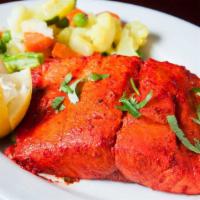 Tandoori Salmon · Boneless salmon delicately marinated and grilled in the tandoor. Comes with side of rice.
