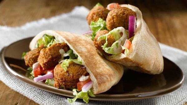 Falafel Sandwich · Vegetarian. Falafel patties (fried) wrapped in pita bread with lettuce, tomato, pickles, and tahini sauce.
