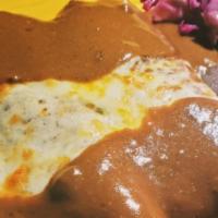 Enchiladas Poblanas · Rolled corn tortillas filled with chicken topped with spicy mole salsa.