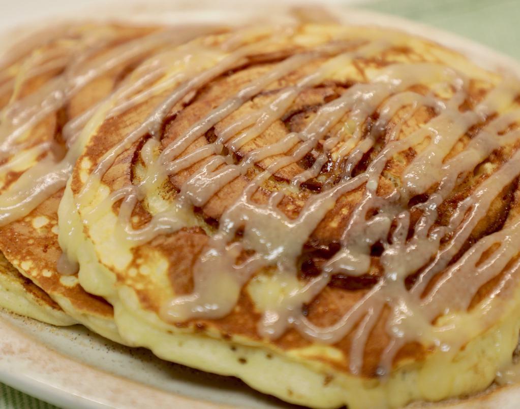 Cinnamon Roll Pancakes · Three pancakes with cinnamon swirl filling topped with homemade icing
