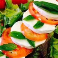 Caprese Salad · Mixed greens topped with fresh mozzarella slices, tomatoes, and fresh basil.