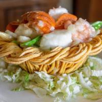 Seafood In A Lovers Nest · Jumbo shrimp sea scallops fresh lobster and a selected assortment of vegetables sauteed in g...