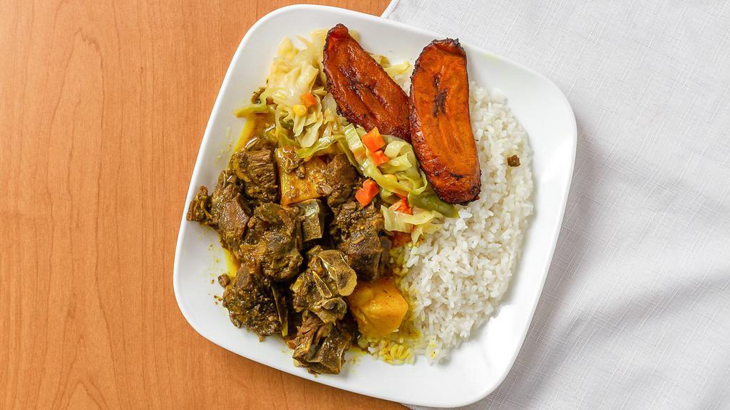 Curry Goat · Goat stewed with curry served with two sides.