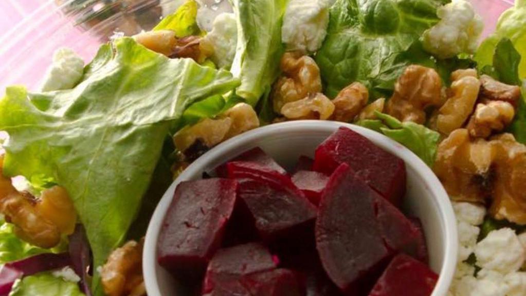 Beet & Goat Cheese Salad · A bed of mixed greens is served with goat cheese, cranberries, roasted walnuts and beets. Best served with our homemade honey pomegranate vinaigrette.