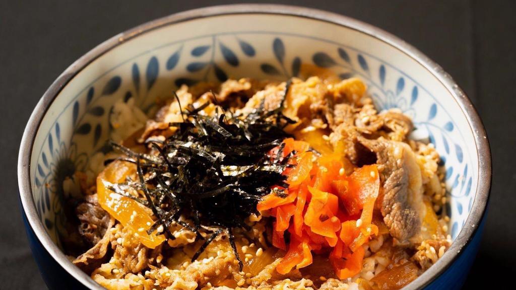 Gyudon · Marinated sliced beef and caramelized onion served with a scallions nori red carrot and naruto over rice.