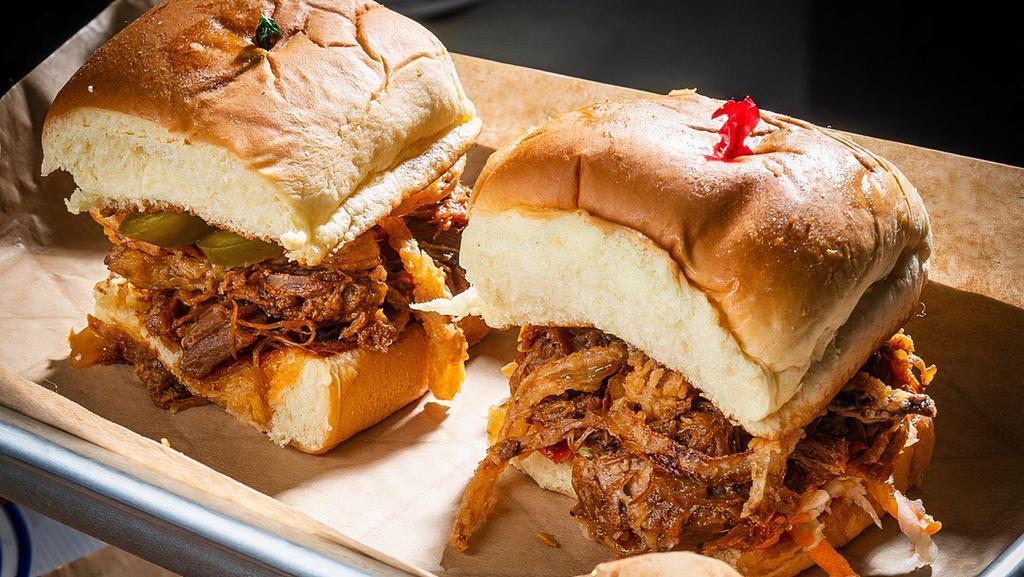S&B Sloppy Cue Sliders · Blend of our smoked beef and pork, slow-cooked with onions, red bell peppers, and our secret blend of sauces. Served on hawaiian-style sweet rolls. Jalapeño upon request.