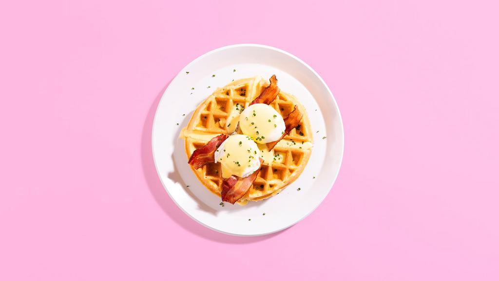 Waffle Benedict · A fluffy Belgian waffle topped with poached eggs, crispy bacon, creamy Hollandaise, and chopped scallions.