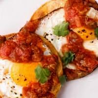 Huevos Rancheros · Sunny-side up egg, crispy corn tortilla, chorizo, salsa roja, black beans.