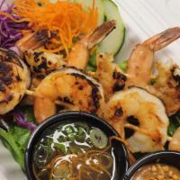 Shrimp Skewers (2) · Marinated with lemongrass, garlic, and ginger.  Served on a bed of lettuce with choice of sa...