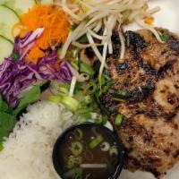 Pork Chop Platter  · Grilled pork chops served over white rice with fresh herbs and vegetables.
