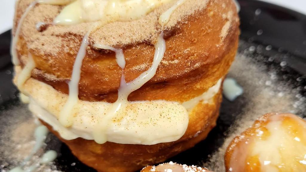 Churro Cheesecake Stuffed Donut · Tossed in cinnamon sugar and filled with cheesecake.  Topped with condensed milk drizzle.