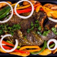 Fbaked Fish · Our  oven-baked tilapia fish, seasoned with local spices and served with fried or boiled pla...