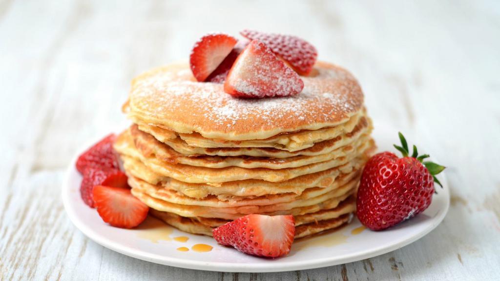 Strawberry Buttermilk
Pancakes · Three perfectly fluffy strawberry pancakes served with a side of butter and syrup.