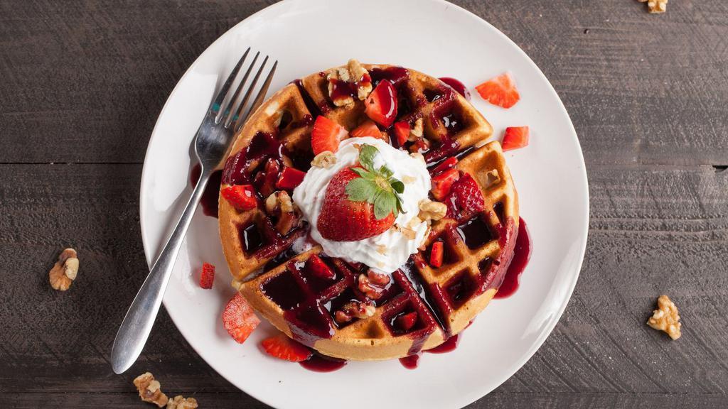 Strawberry Belgian Waffles · Crisp cake of batter baked in a waffle iron topped with fresh strawberries served with a side of butter and syrup.