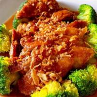 Duck Tamarind · Crispy Duck on bed steam Broccoli  in Tamarind sauce and topped with fried red onion.