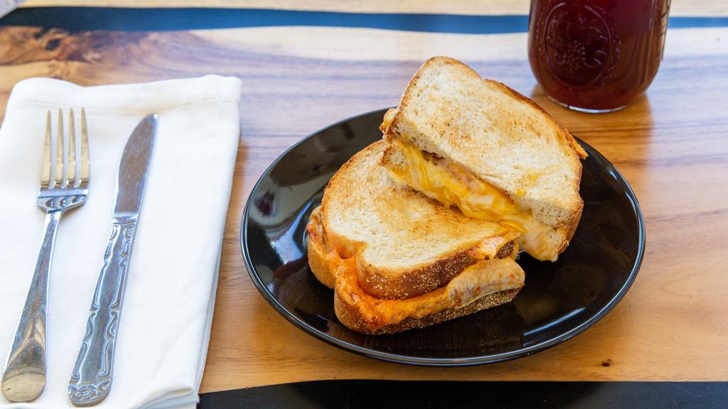 Gourmet Grilled Cheese · Toasted sourdough bread, melted American, cheddar & pepper jack cheese, sliced tomato and Dijon mustard.