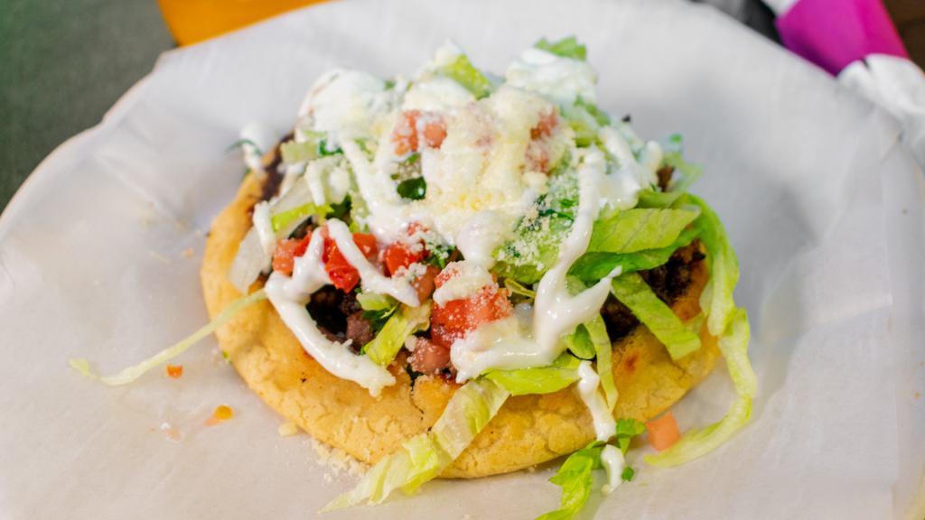 Sopes · Corn dough topped with your choice of meat, beans, lettuce, cilantro, onions and tomato.