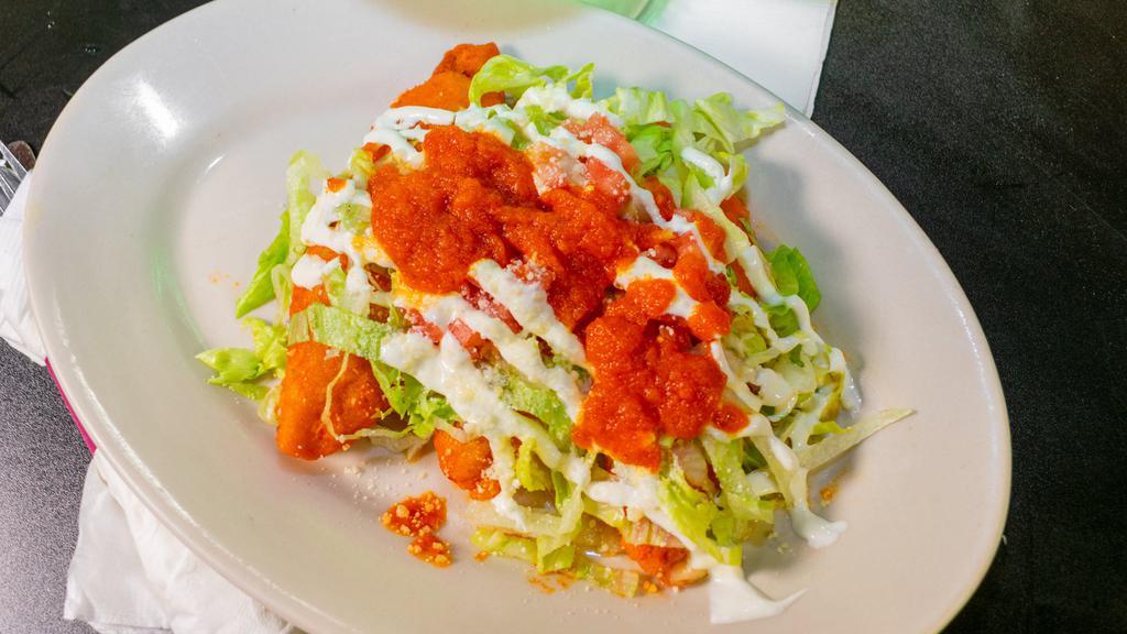 Molotes · Corn based pastry filled with chicken topped with sour cream, queso fresco, lettuce, and tomato sauce.