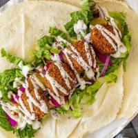 Falafel · Falafel with hummus spread, lettuce, tomatoes, pickles, onions, sumac spice with tahini sauce.