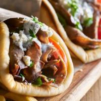 Veggie Gyro Wrap · Roasted green peppers, mushrooms, tomatoes and onions wrapped in a fresh pita bread topped w...