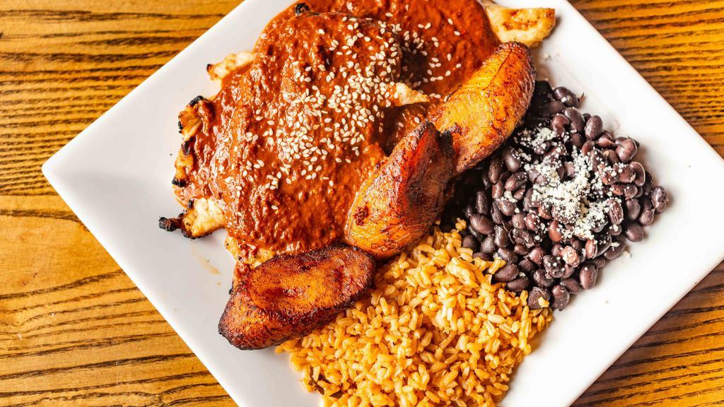Chicken Mole · Grilled chicken breast served with rice, black beans topped with homemade mole sauce, sesame seeds and fried plantains.