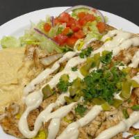 Chicken Shawarma Lunch · Chicken Shawarma over rice with tahini sauce and pickles. Served with hummus, salad and pita...