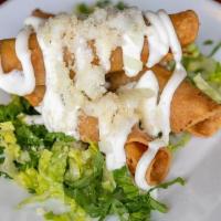 Flautas De Pollo · Three Crispy tacos stuffed with shredded chicken, and topped with lettuce, onions, sour crea...