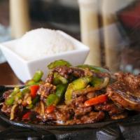 Sizzling Short Ribs · Sizzling beef short ribs with onion and bell peppers. Served with rice on the side.