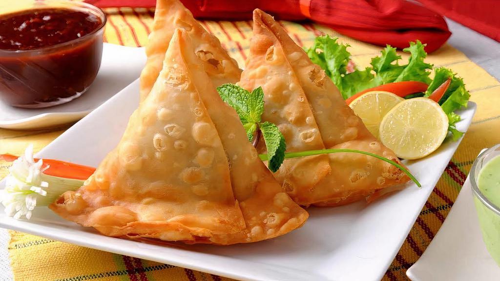 Vegetable Samosa (2 Pieces) · Deep-fried crispy turnovers stuffed with mildly spices potatoes and green peas, served with mint and tamarind chutney.