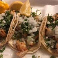Shrimp Tacos Traditionales · Three soft corn tortillas, meat, served with cilantro, onions & limes.