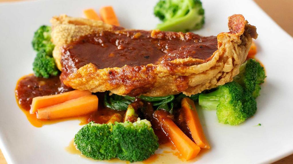 Crispy Red Snapper · Filet of red snapper with sweet and spicy curry or tamarind sauce with a side of vegetables.