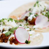 Chicken Tinga Tacos · Two pieces onion, cilantro, queso fresco, and crema.